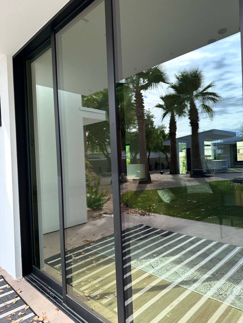 Clear sliding doors reflecting palm trees